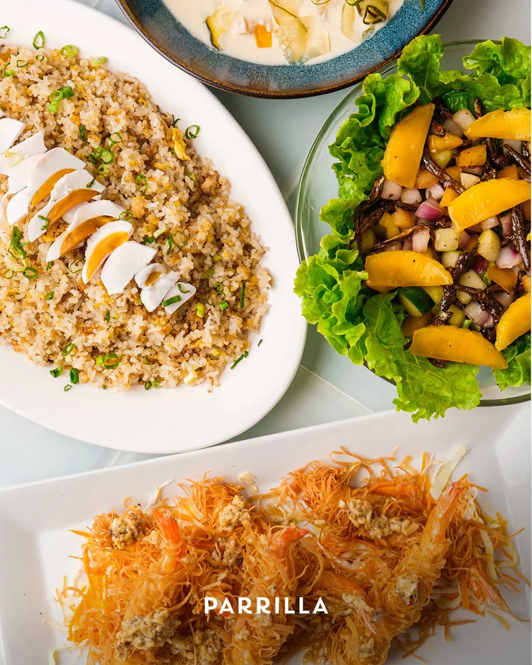 A Parrilla spread: salted-egg fried rice, mango and dilis salad, and crispy shrimp