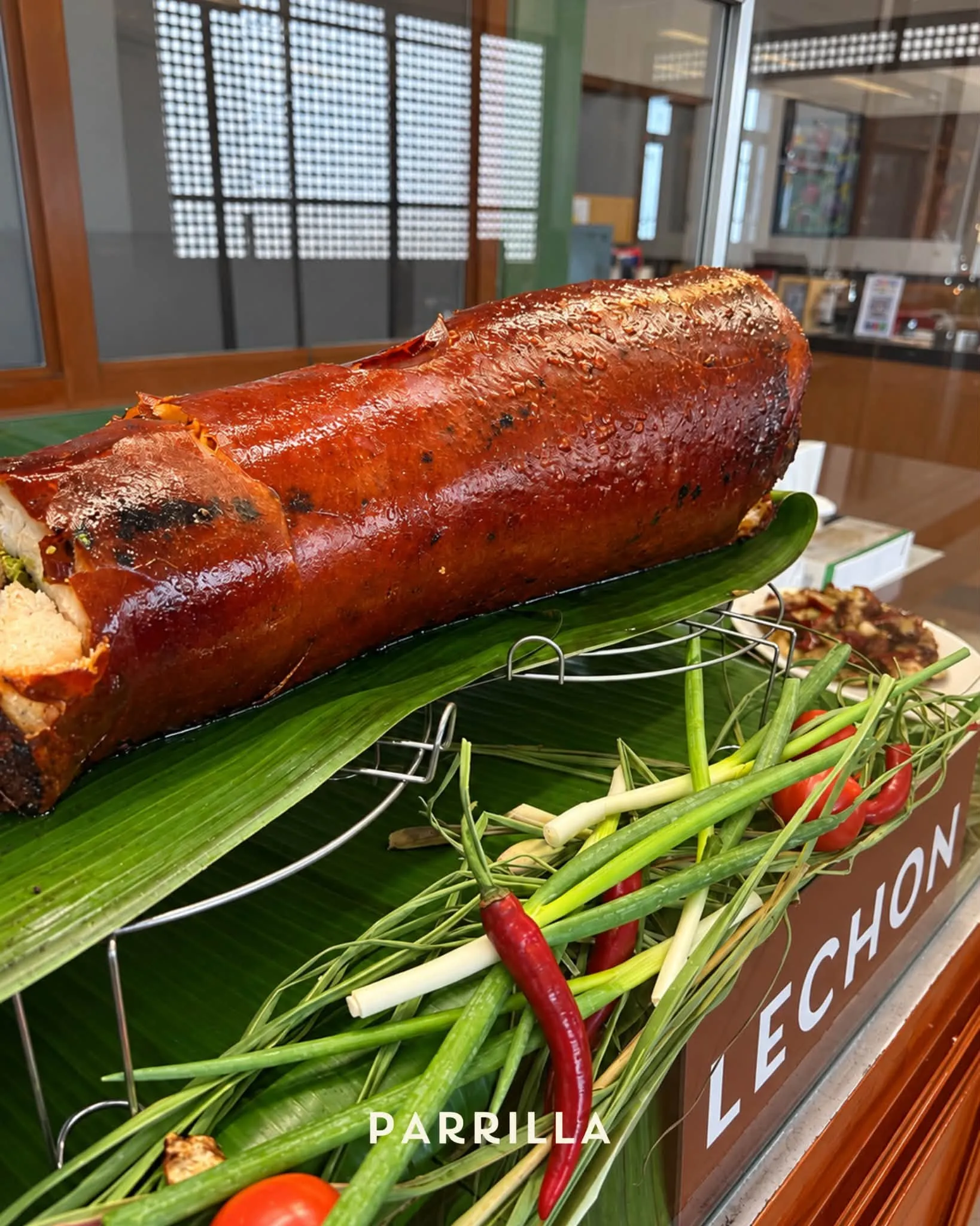 A whole roasted lechon on banana leaves, glossy and golden, ready for a celebration